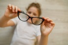  Child girl holding black-framed glasses in her hands. Glasses in focus, the child is blurred. Vision impairment concept
     -  (crédito:  Getty Images)