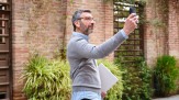  Mature man recording a video on a smartphone while holding a laptop outdoors
     -  (crédito:  Cristina Garcia / Envato)