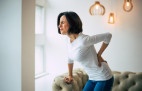  Young woman is holding her lower back while suffering from severe back pain.
     -  (crédito:  Povozniuk)