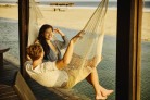  Wide shot of smiling and laughing millennial couple relaxing in poolside hammock at luxury beach resort during romantic tropical vacation
     -  (crédito:  Getty Images)