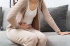 The woman with a stomachache is holding her stomach in pain, sitting on the sofa in the living room. she is suffering from a stomachache. Healthcare and medical concept.
- (crédito: DINO) The woman with a stomachache is holding her stomach in pain, sitting on the sofa in the living room. she is suffering from a stomachache. Healthcare and medical concept.
- (crédito: DINO)