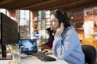  Call center worker wearing audio headset in office using AI to generate call scripts during conversation with customers. Woman doing customer support job using AI to summarize clients issues
     -  (crédito:  Dragos Condrea)