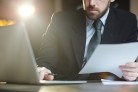  Portrait of modern bearded businessman working in office using laptop and reviewing documentation
     -  (crédito: DINO)