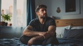 A man with a worried expression sits on a bed in a sunlit room, capturing a sense of introspection and solitude.
- (crédito: standretcompany) A man with a worried expression sits on a bed in a sunlit room, capturing a sense of introspection and solitude.
- (crédito: standretcompany)